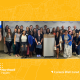 A large group of Northwell team members standing together in front of a large Northwel Health backdrop.