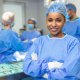 Young, female surgical tech in an operating room smiles with arms crossed